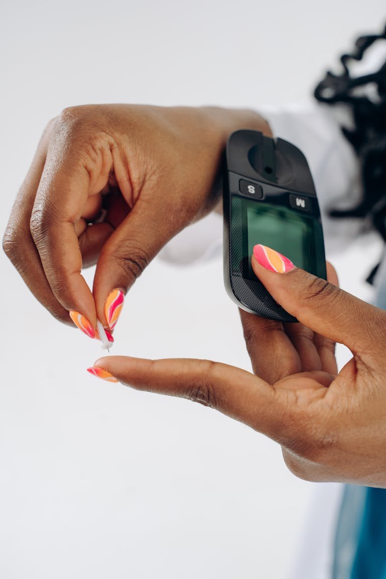 A person's hands using a glucose meter to check blood sugar levels.